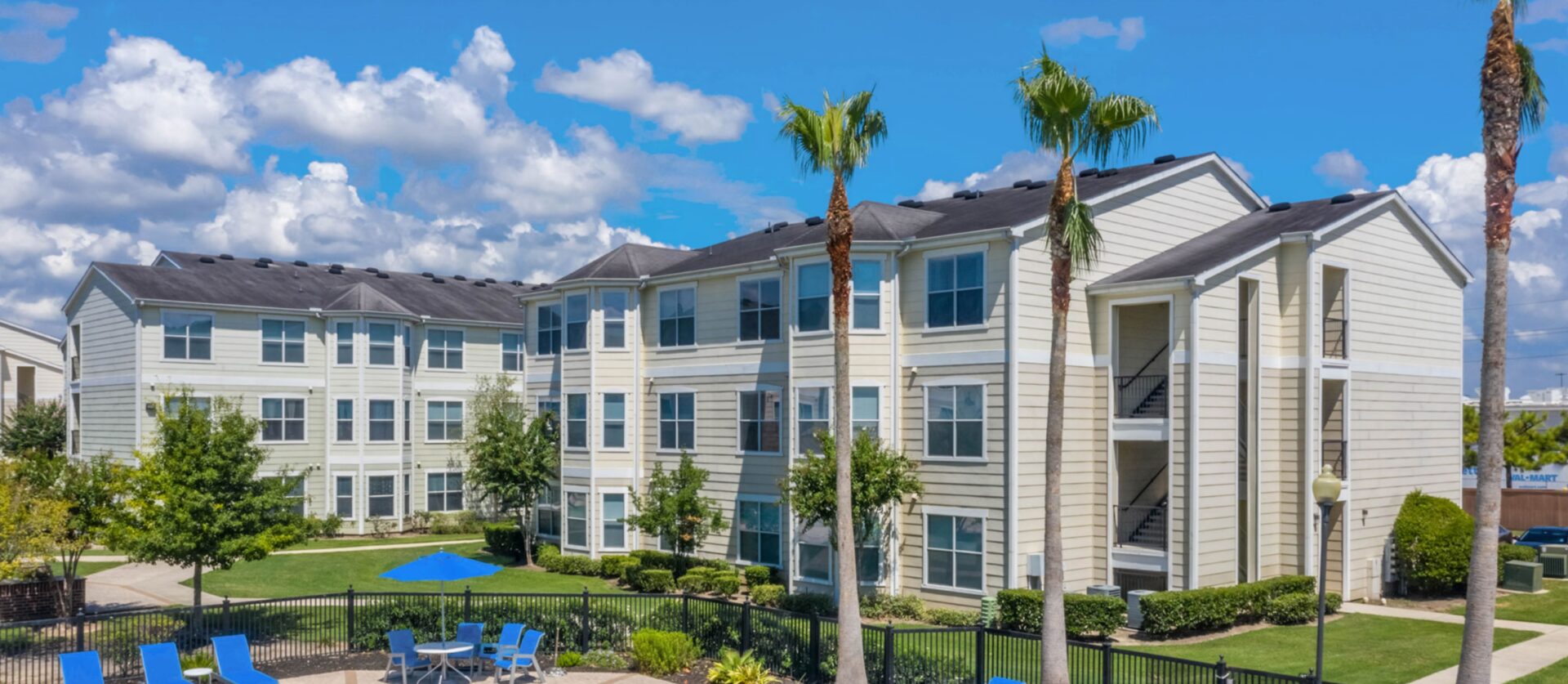 bright condo with grassy yard, palm trees in foreground